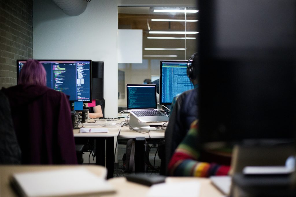 Coders working side by side at desks.